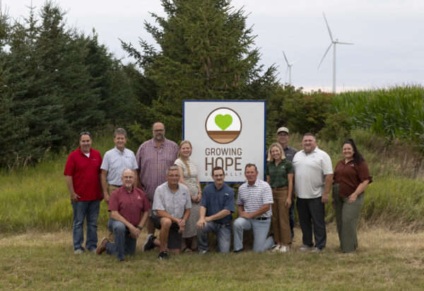 Group of Beck's Hybrids and Growing Hope Globally staff and volunteers around a Growing Hope Globally Sign